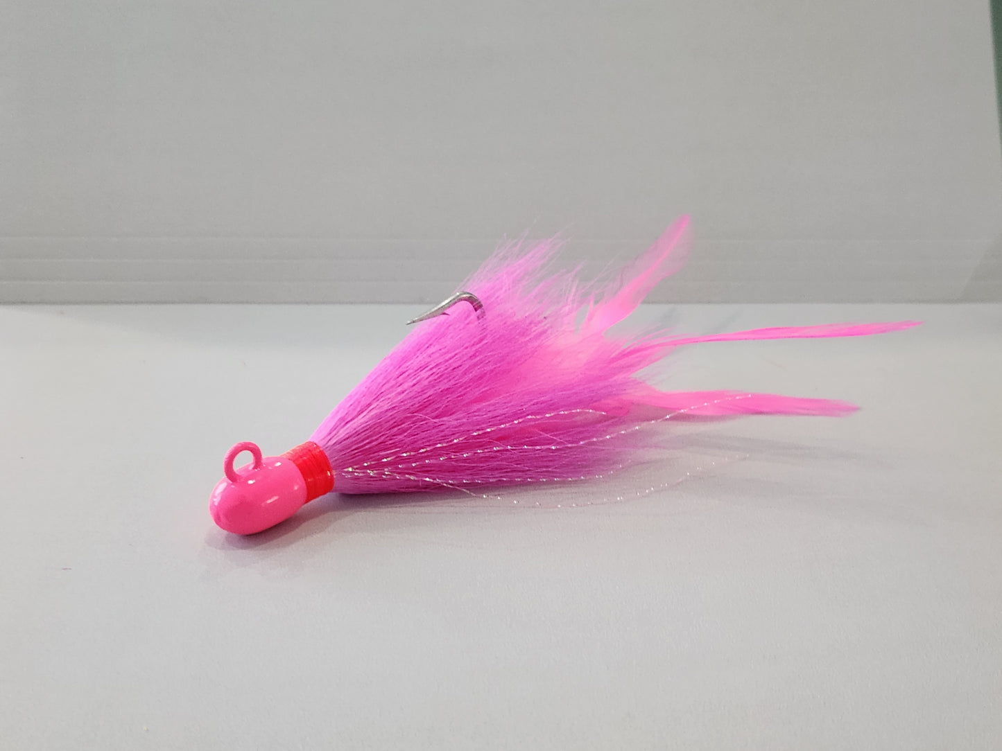 Pink bucktail jig custom with feathers and flash.