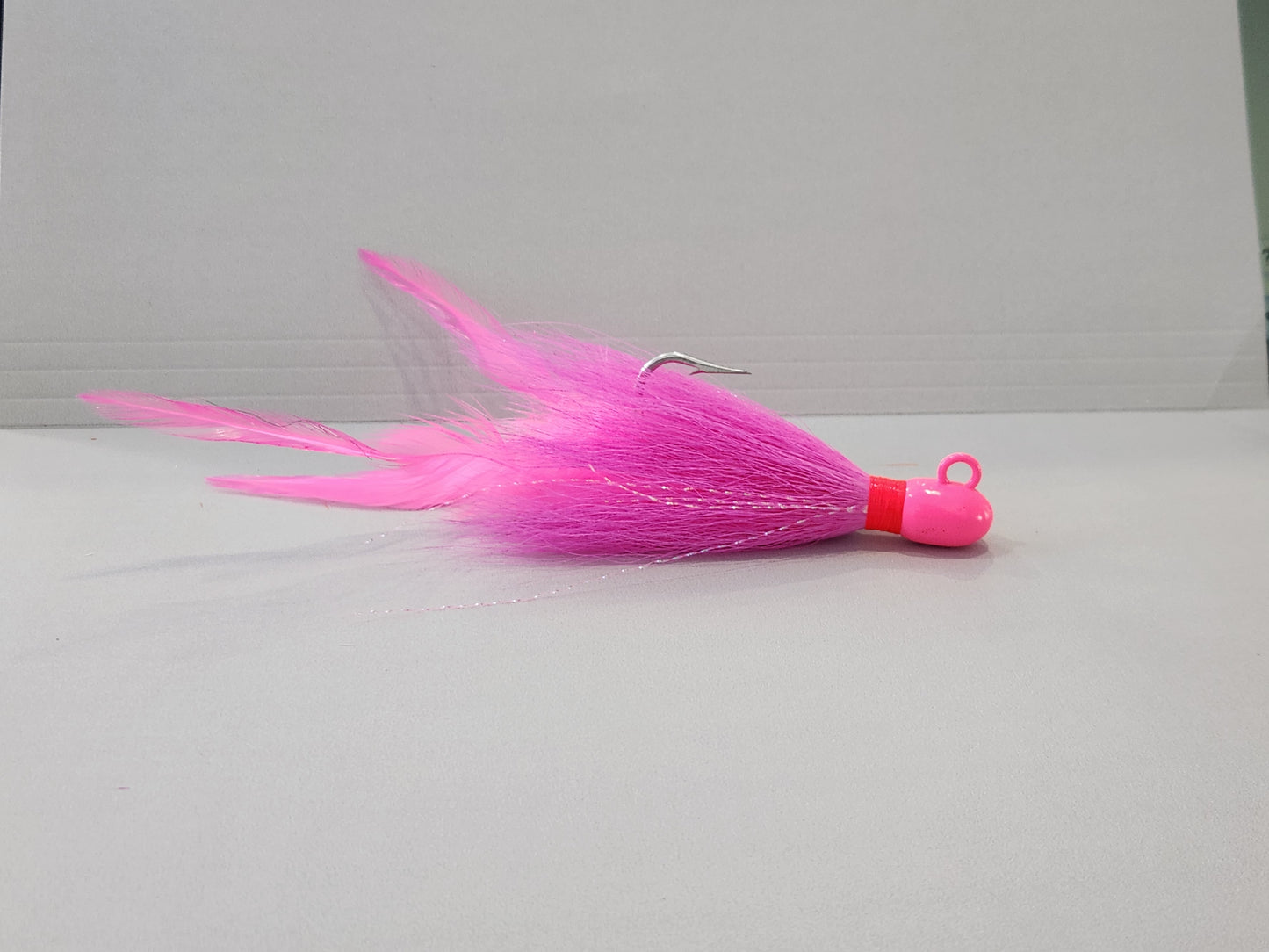 Pink bucktail jig custom with feathers and flash.